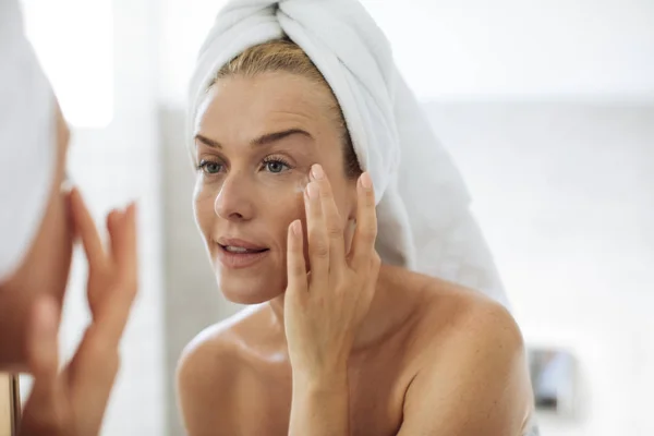 depositphotos_170226136-stock-photo-woman-applying-moisturising-creme-on